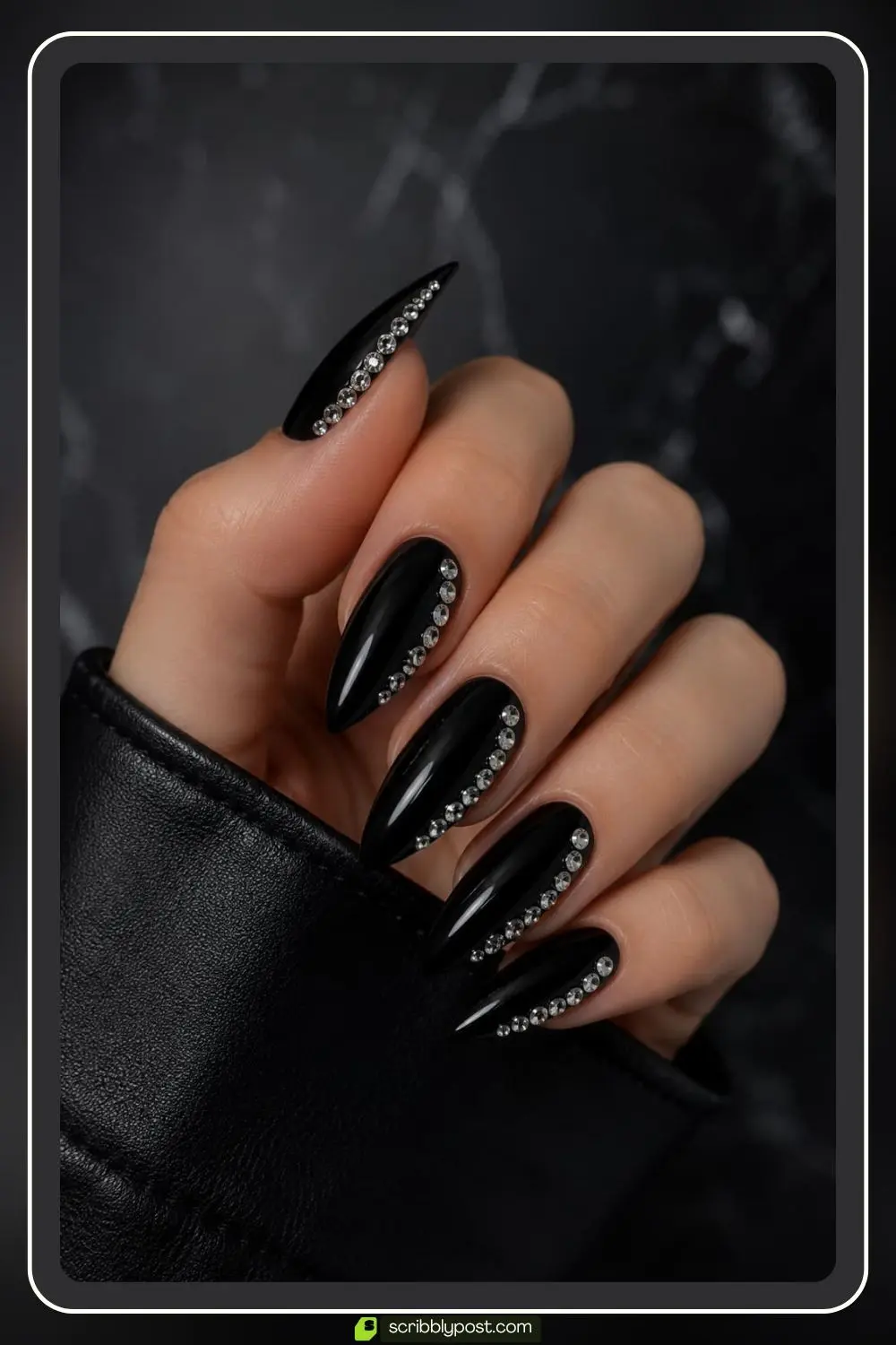 Glossy black nails with silver rhinestones placed along one side edge of each nail