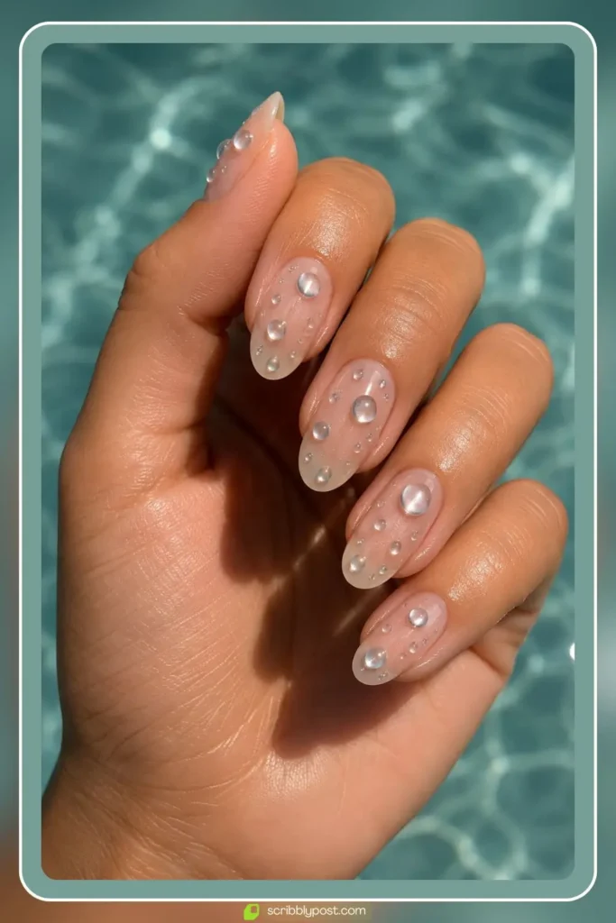 Sheer nails with raised chrome water droplets as 3D accents