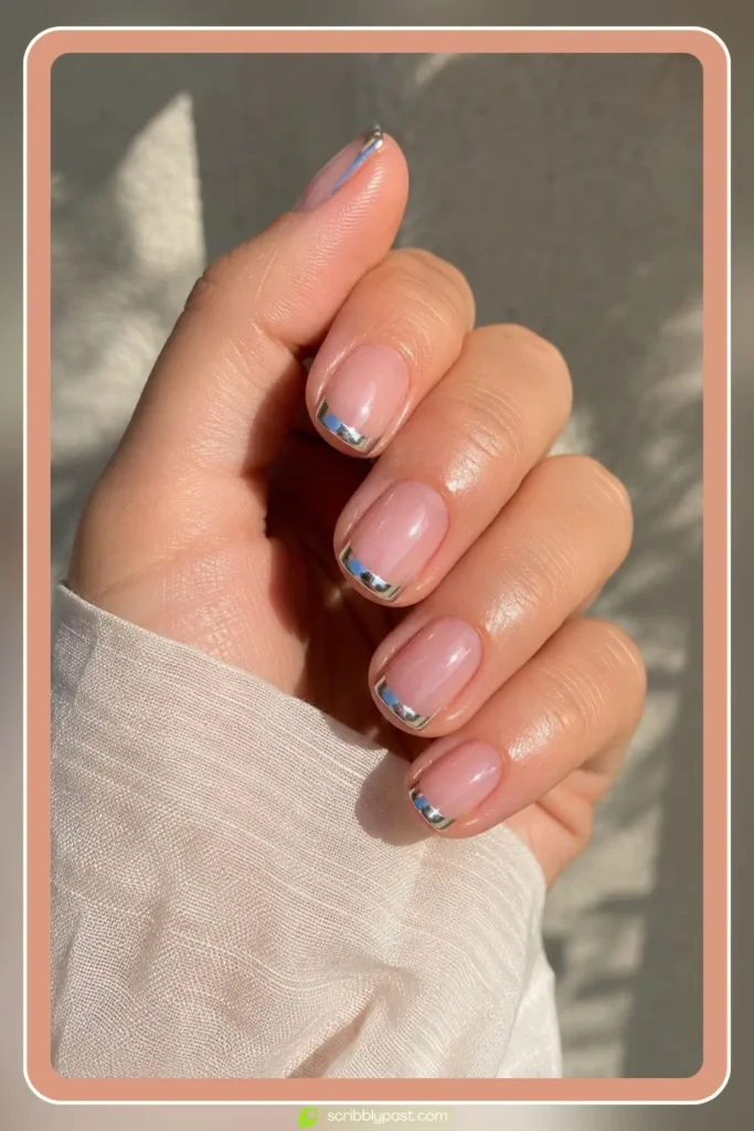 Sheer pink nails with silver chrome french tips catching summer light