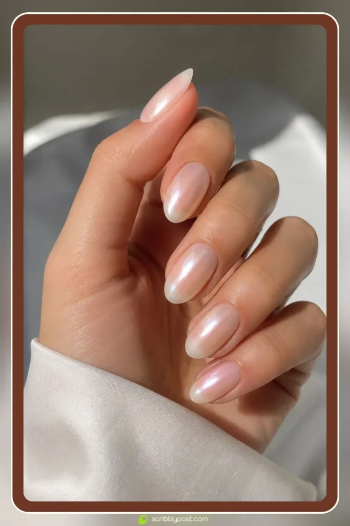 Short almond nails with milky base and pearl chrome powder creating a glazed donut shine