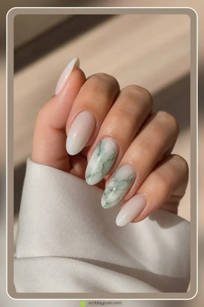 Jade green accent marble nail with milky base on oval shape for a subtle marble accent look