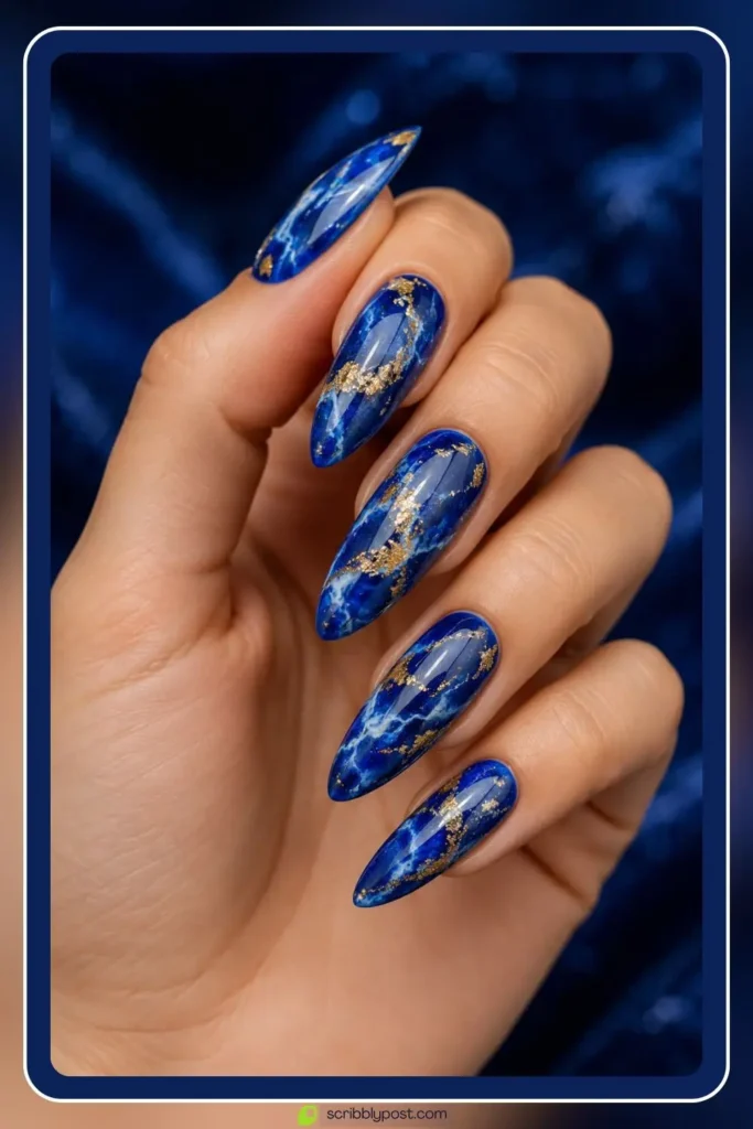 Lapis blue marble nails with gold foil flake veining on deep cobalt gel base on almond shape