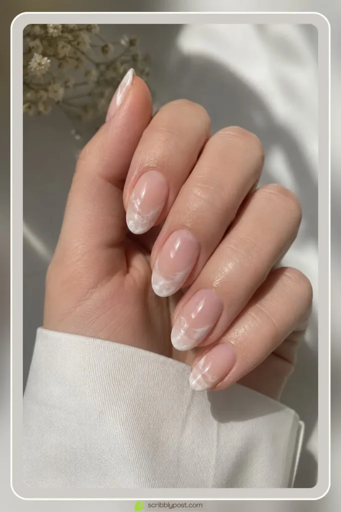 Milky marble French tip nails with veined white tip on a sheer base for a clean marble effect