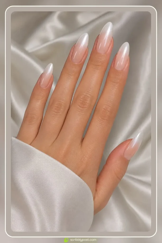 Ombre nails fading from sheer nude at the cuticle to bright pearl white at the tips