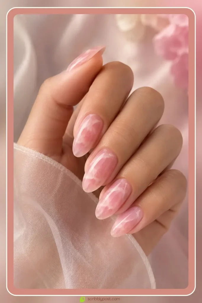 Rose quartz pink swirl marble nails on oval shape with soft pink base and glossy finish