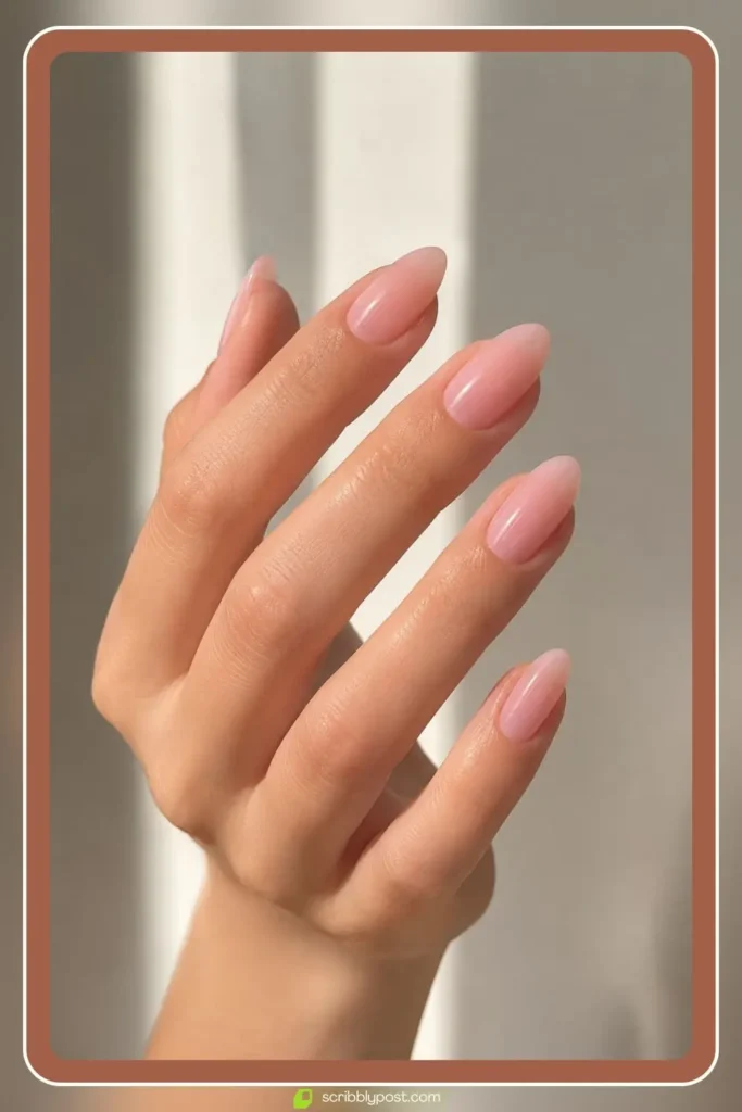 Sheer baby pink jelly nail polish on almond nails with a glassy clean girl finish