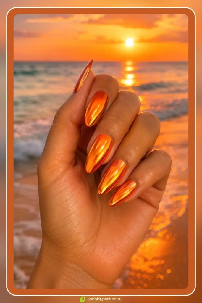 Vivid orange chrome nails with warm metallic shine like a summer sunset