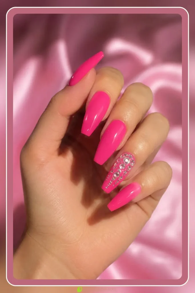 Barbie pink nails with rhinestone accents on long nails