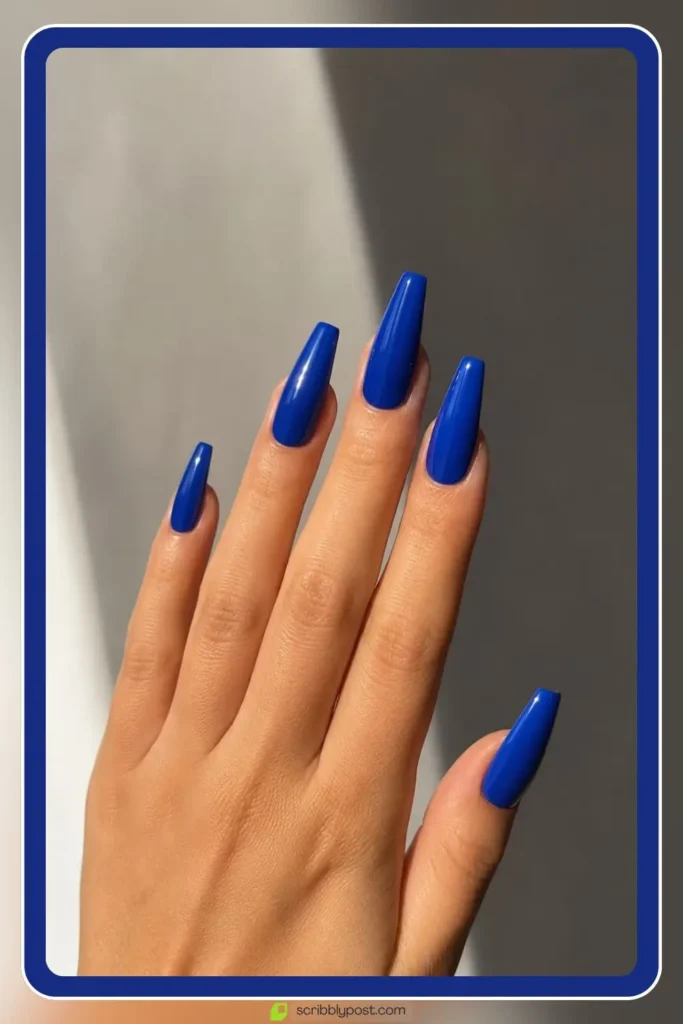 Long blue acrylic nails in coffin shape with glossy finish