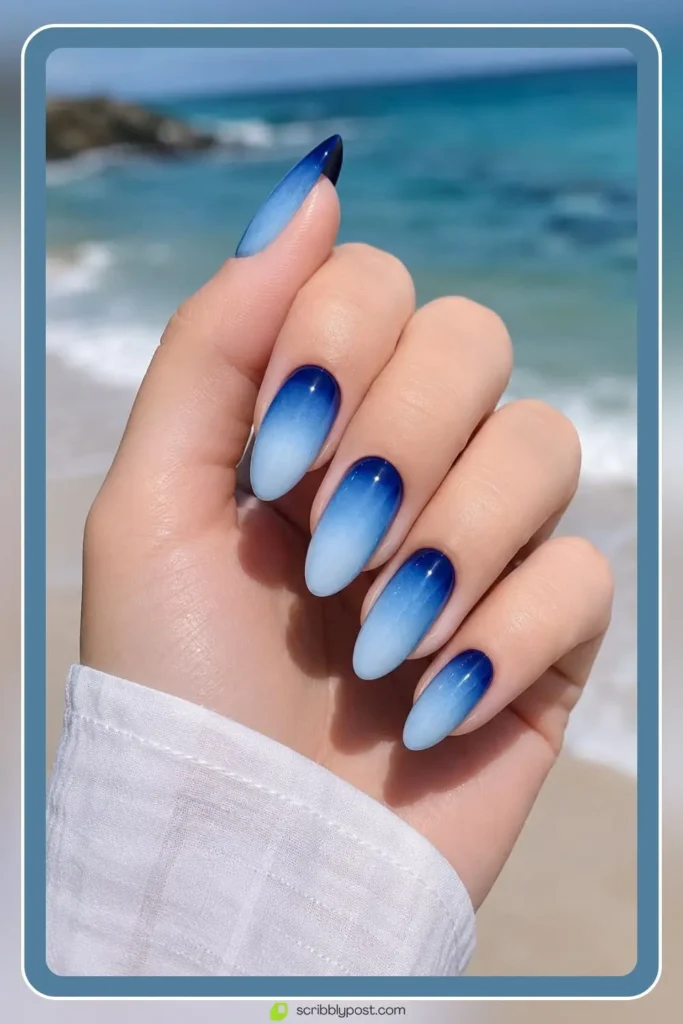 Blue ombre nails fading from navy to sky across the hand