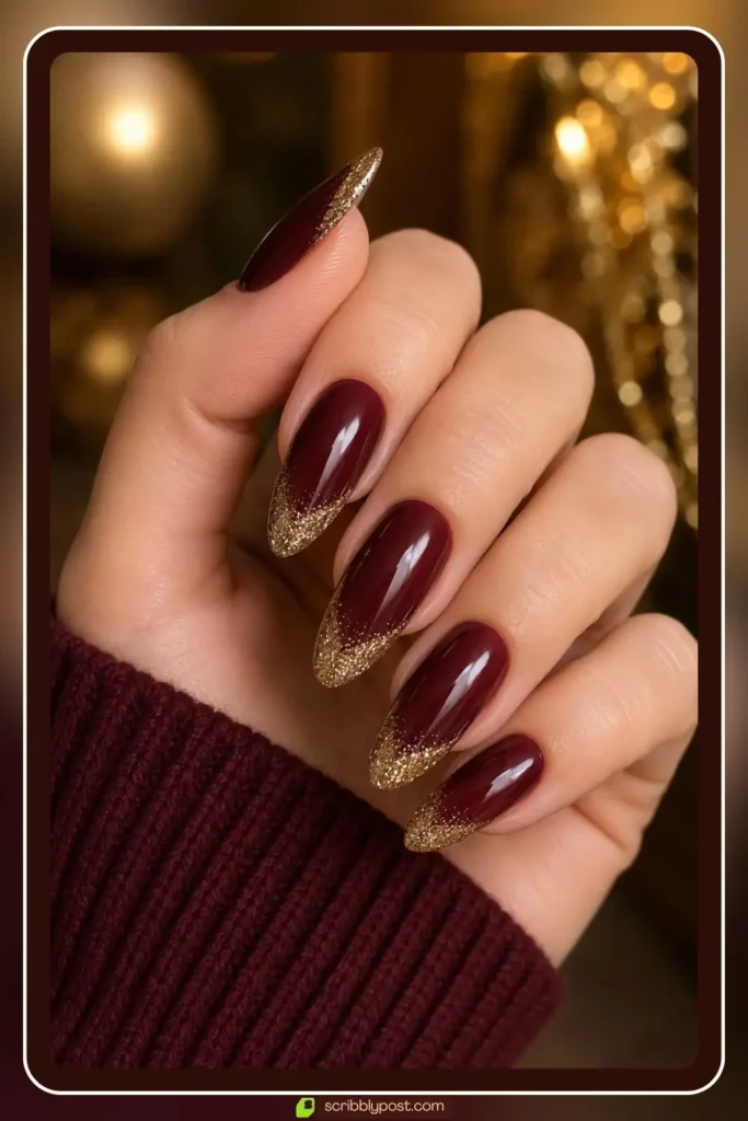 Burgundy and gold nails with glitter french tips on almond shape