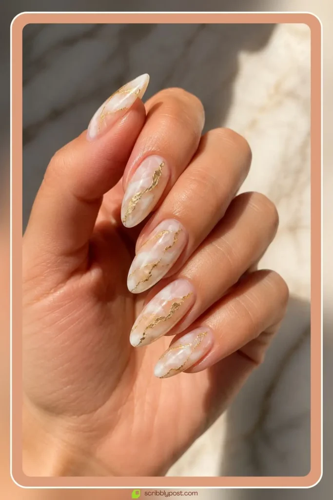 White marble nails with gold leaf veins on almond shape