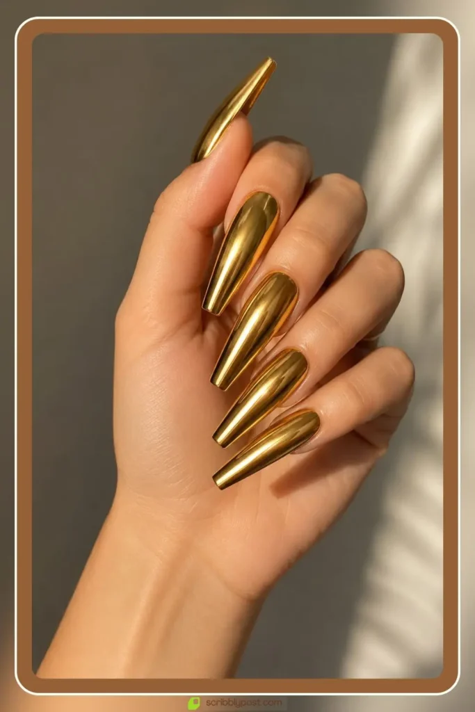Long gold acrylic nails in coffin shape with full metallic finish