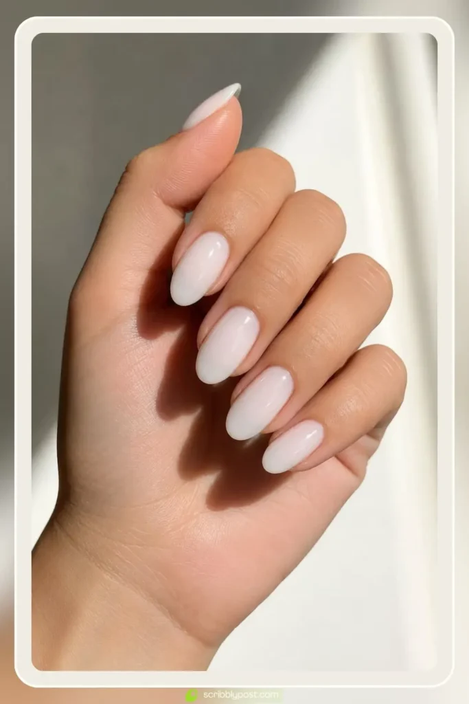 Milky white nails with sheer creamy finish on short almond shape