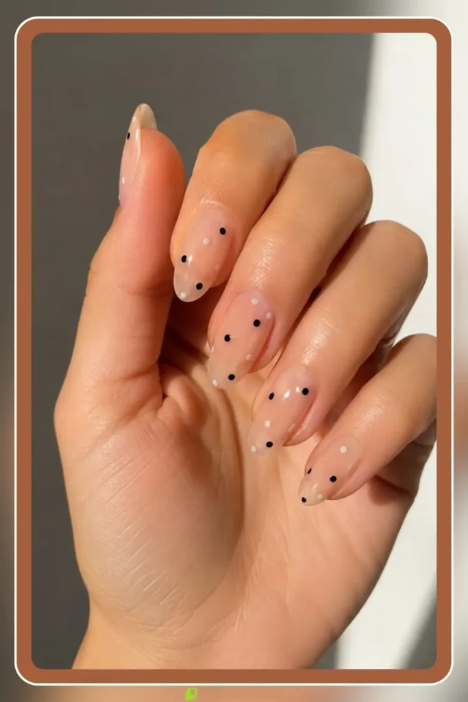 Clear base with a few scattered painted dots, Negative Space Dots, minimal airy manicure