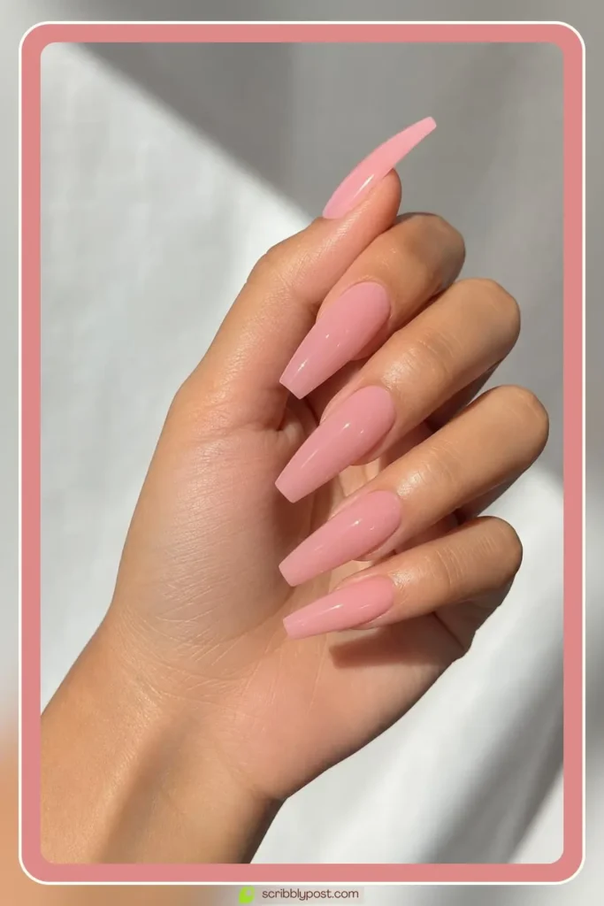Long pink acrylic nails in sculpted coffin shape
