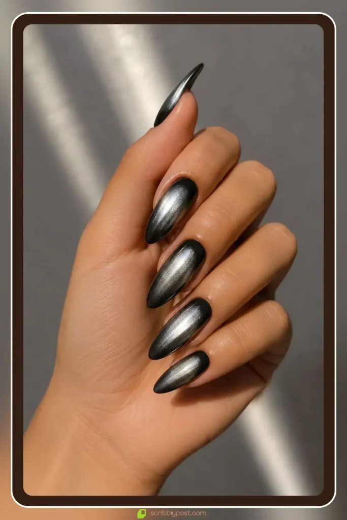 Silver chrome aura glow over black base on long almond nails