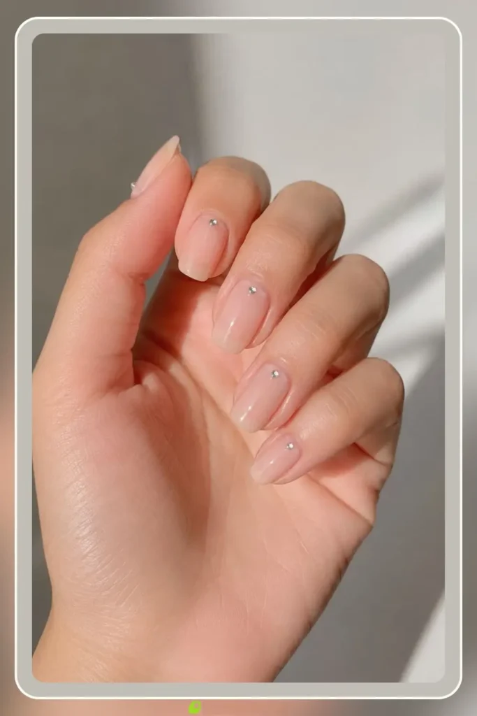 Bare nude base with a single rhinestone at the cuticle, Simple Rhinestone Nail Designs, glam no-tool manicure