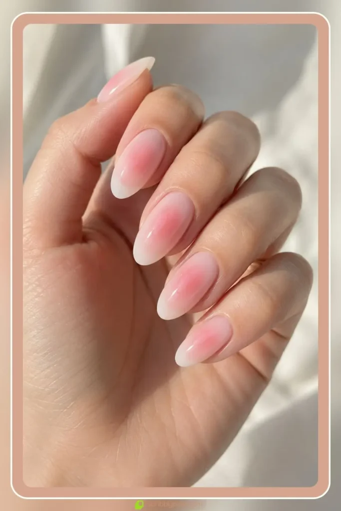 Soft blush aura glow blended over milky white almond nails