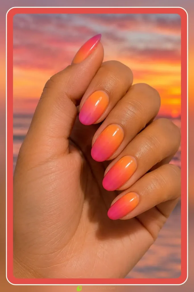 Pink and orange sunset aura gradient on glossy oval nails