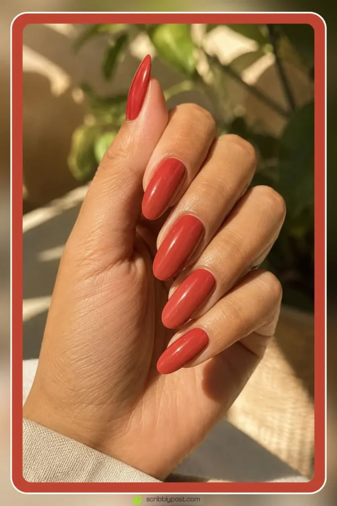 Deep coral red nails in warm spiced solid finish