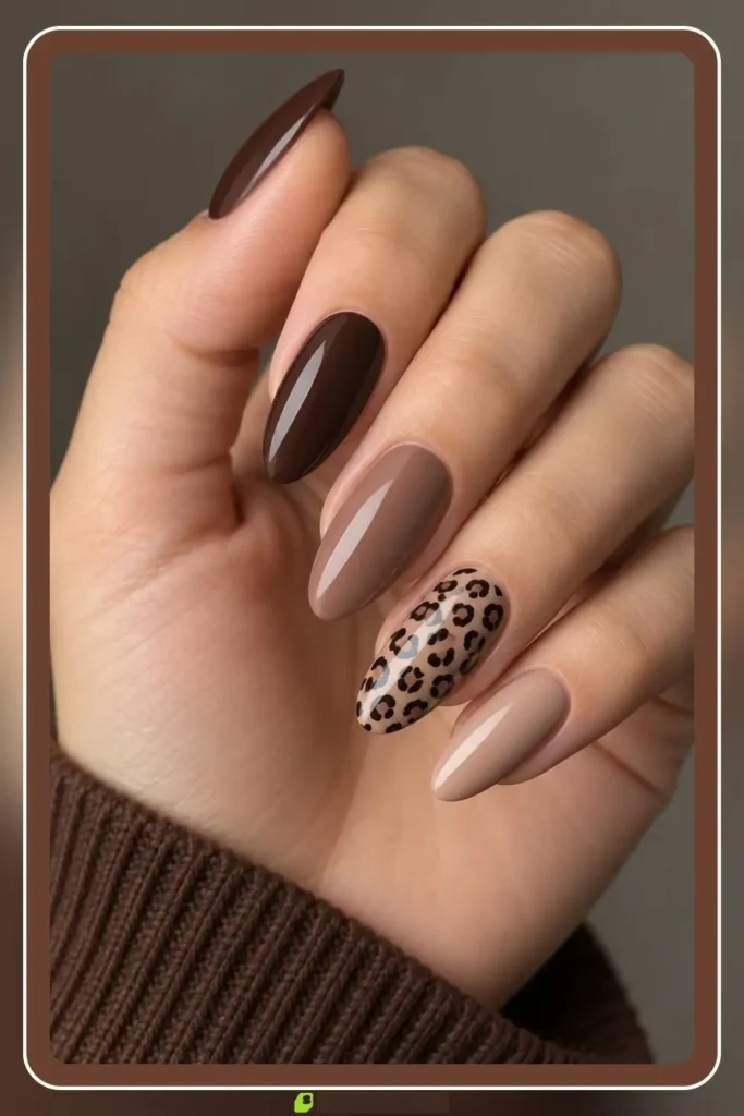 Brown fall nails with a nude base and small leopard print accents
